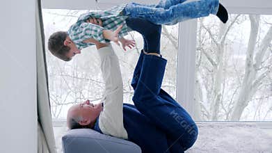 Granddad fool around with grandchildren lying on floor at home