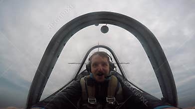 Smiling pilot sitting in the cockpit of a light aerobatic aircraft, emotions from the flight, aerobatics