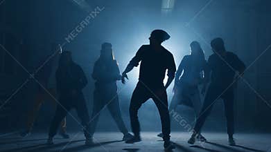 Teens taking part in dancing battle outside.