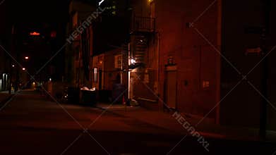 Camera pans to creepy alley at night in downtown city