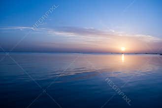 Rose sunrise on the ocean. Sun under the red sea in the morning. Sunset and reflex on water in the evening. Sunrise and blue sky