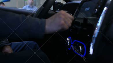 Man using large touchscreen dashboard in car, testing new vehicle functions