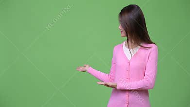 Young beautiful Asian woman showing something