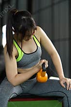 Young beautiful woman doing exercise with kettle bell at fitness centre