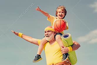 Like sports. Joyful old-aged man and cute little boy practicing sport and healthy lifestyle over sky background. Fathers