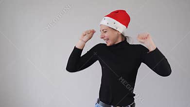 Young millennial woman dancing happily in santa hat. 2021 new year
