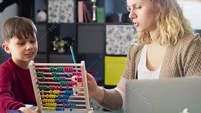 Video of boy with his mother learns to count with an abacus.