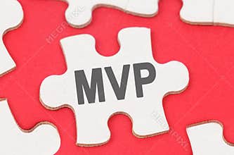 On a red background, among white puzzles lies a puzzle with the inscription - MVP
