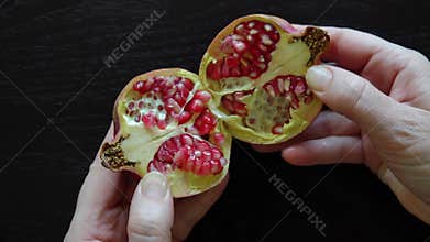 Jewish woman opens a fresh Pomegranate fruit