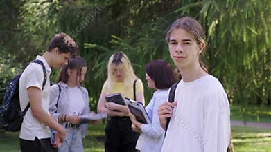 Male student 16, 17 years old with backpack, in school park