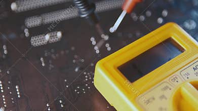 A man checks for the presence of malfunctions in the printed circuit board