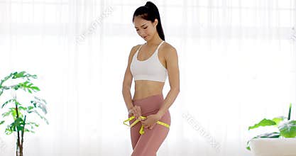 Beautiful young woman measuring her hip. Weight loss concept