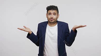 Puzzled confused man with beard in business suit shrugging shoulders and throwing up hands, uncertain about information