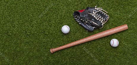 Baseball bat, glove and ball on green grass field.  Sport theme background with copy space for text and advertisment