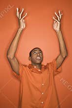 African-American man throwing his arms up in the air.