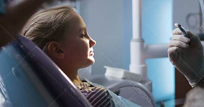 Brave little girl in chair during dental procedure