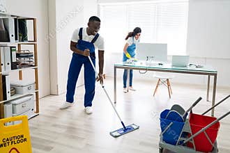 Male And Female Cleaners Cleaning Office