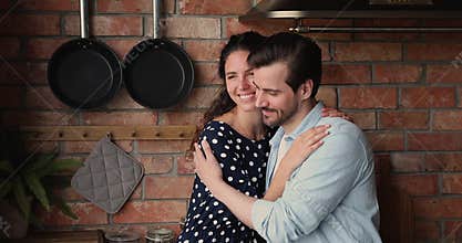 Happy loving young married family couple cuddling indoors.