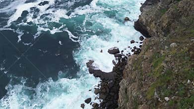 Aerial video shows dramatic cliffs and waves crashing on shore
