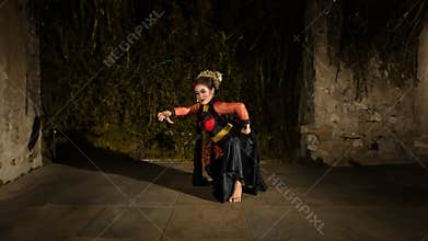 a Javanese dancer makes flexible and flowing movements in time with the rhythm of the music