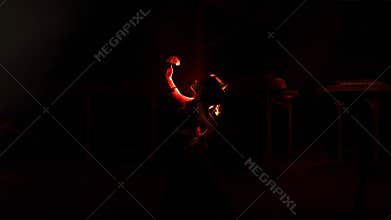 the silhouette of a female dancer holding jewelry that looks like a reflection reflecting in the dim light