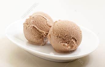 Ice cream scoops on white plate close-up