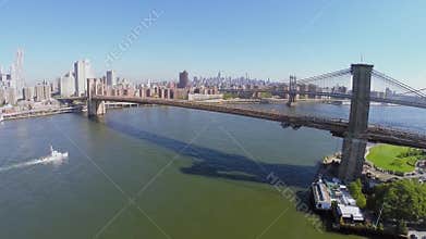Boat sails near Manhattan and Brooklyn Bridge