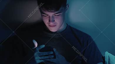 Gadget night man enjoying using phone late in bed