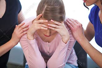 Two women comforting crying girl.