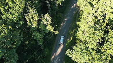 Shooting a car on a narrow road in the middle of the forest. . Drone footage of an ambulance driving down a road in the