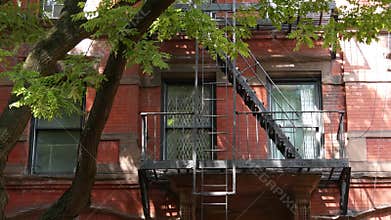 New York City building architecture, Manhattan. Residential house exterior. Red brick, fire escape.