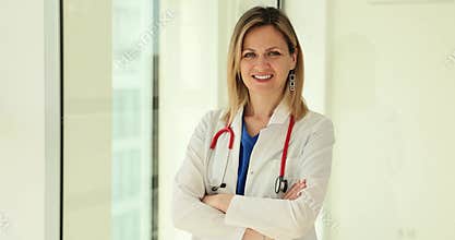Portrait of young female doctor in white coat standing in hospital
