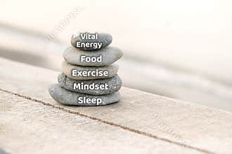 Vital energy, food, exercise, mindset and sleep words written on stones. Healthy living and energy concept