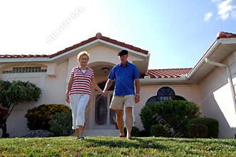 Senior couple in front of home