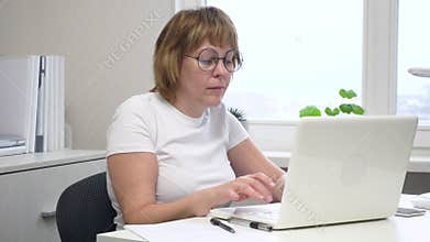 Efficient Workspace: Woman Typing on Computer in Home Office