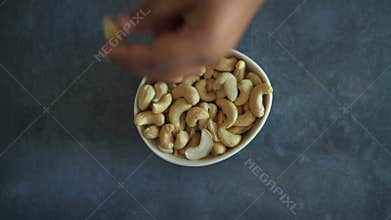 top view of child hand picks cashew nuts