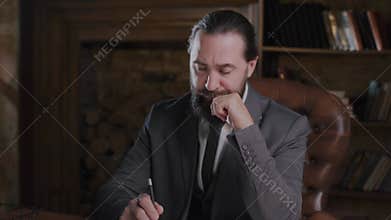 A focused businessman in his office reflecting on work, decisionmaking, showing a serious approach