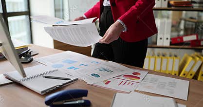 Female manager reviews infographics and puts papers on table