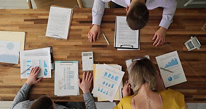 Tired colleagues hit heads on clipboards sitting at table