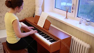 Young woman in T-shirt is playing classic music on