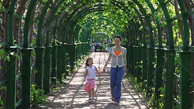 mother and her little daughter go through arched