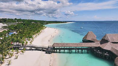 Aerial view of bungalow, white sandy beach, sea and palms