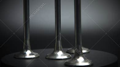New internal combustion engine valves on a rotating platform on a black background. Spare parts for internal combustion