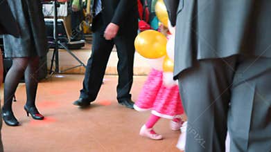 two little girls runs on dancing area with people