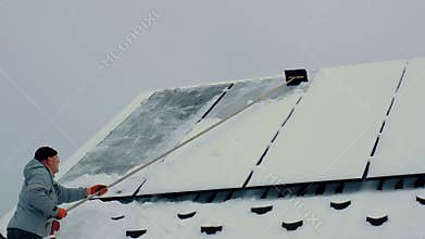 A man clears snow from solar panels. Selective focus.