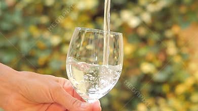 Filling up a glass of water outdoors
