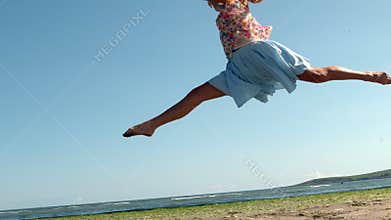 Gorgeous blonde doing ballet jump on beach