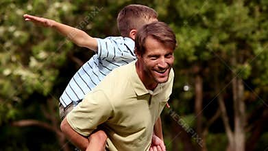 Father giving a piggy back to his son