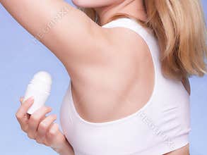 Girl applying stick deodorant in armpit. Skin care