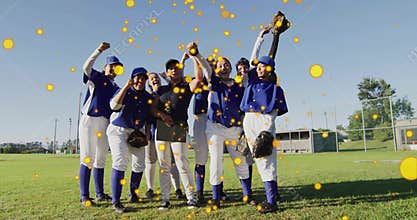 Celebrating baseball players and coach pumping fists on baseball field, with gloves and clipboard